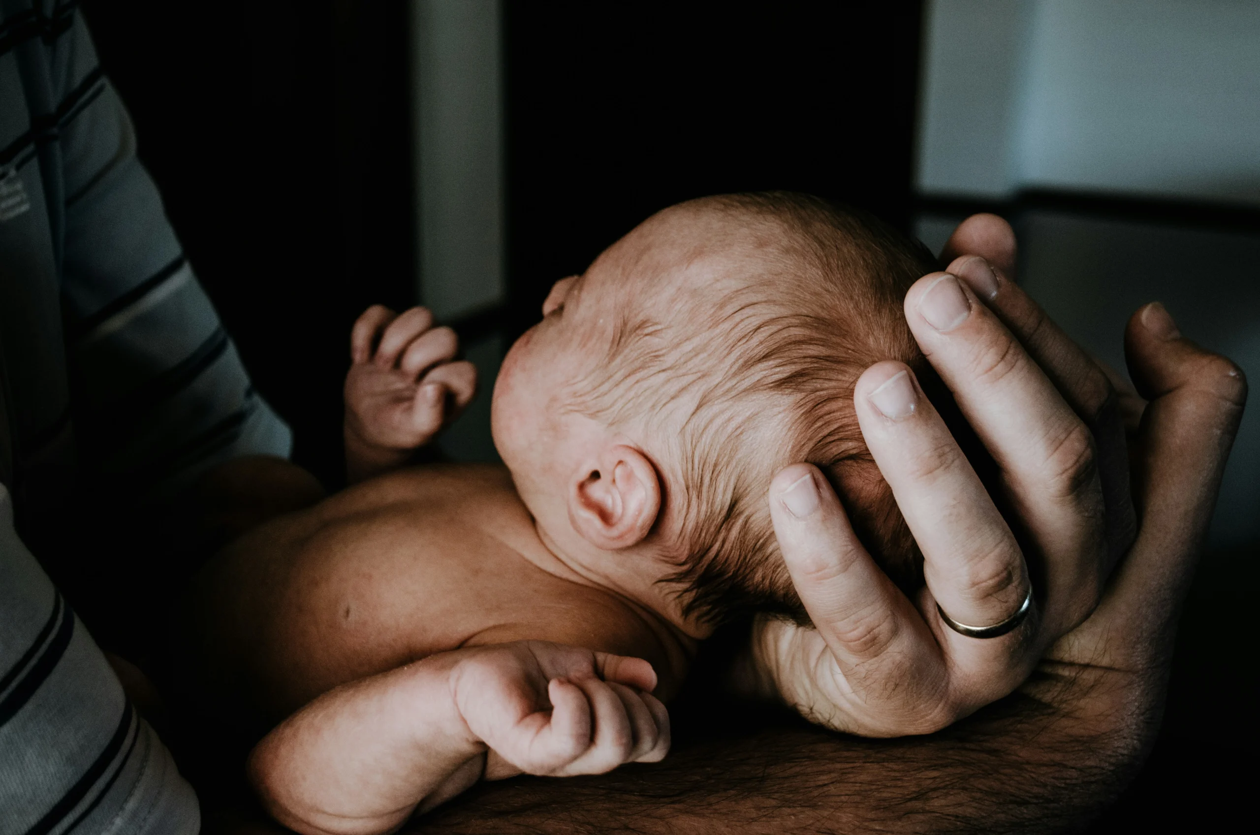 into-life-Mann hält Baby in Säuglingsalter